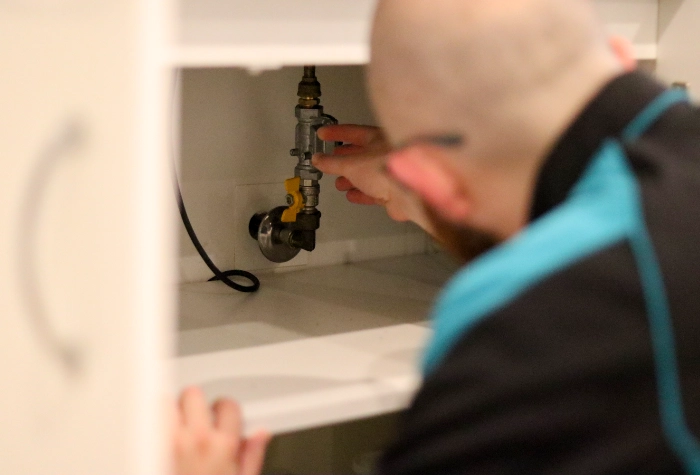 The Clean Plumber emergency plumbing Professional plumber inspecting a drain after an emergency call