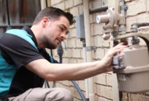 A gas plumber inspecting a gas meter